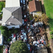Fotografia aérea realizada por drone do desmanche fiscalizado em Ibiraiaras mostra a estrutura do estabelecimento, carcaças e peças de veículos, casas e carros