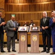 Governador Eduardo Leite, ex-chefe de polícia Fernando Sodré, novo chefe de polícia Heraldo Guerreiro e o secretário Sandro Caron ladeiam as fotos de Sodré e Guerreiro, que foram descerradas momentos antes.