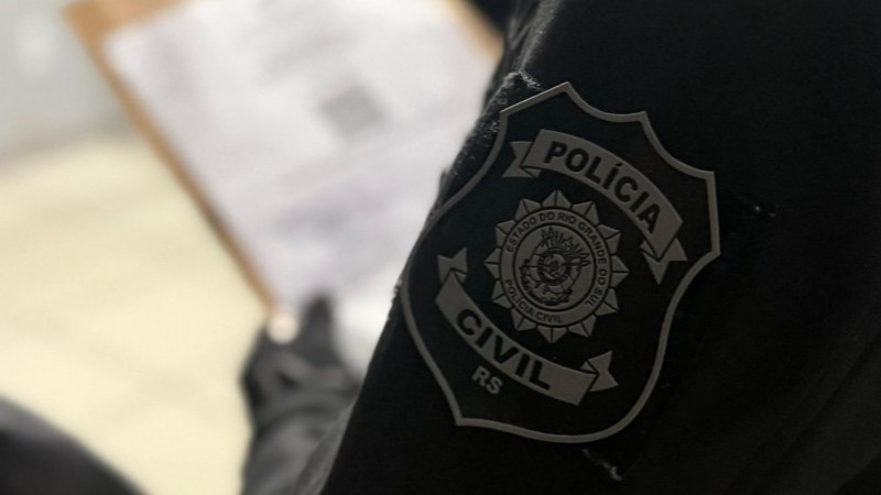 A imagem mostra parcialmente um agente da Polícia Civil uniformizado que segura envelope e se prepara para a operação O Infiltrado