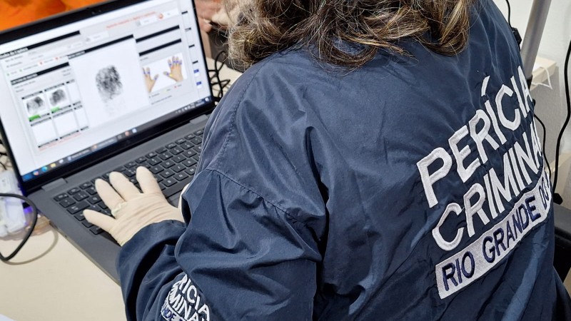 Agente uniformizada do IGP opera computador onde é possível na tela o sistema de inclusão de digitais para emissão da Carteira de Identidade.