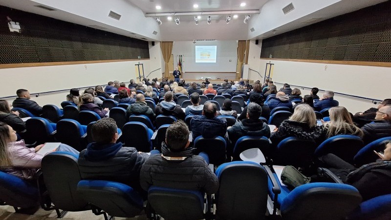 Pessoas reunidas, sentadas em um auditório