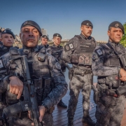 A imagem mostra um grupo de policiais do batalhão de operações especiais. Todos estão fardados com o uniforme do batalhão e usando boinas da cor preta. Os dois primeiros da foto empunham fuzis, enquanto os demais estão em posição de descanso