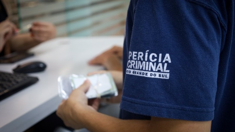 Foto mostra Servidor da Per&iacute;cia Criminal entregando documentos 