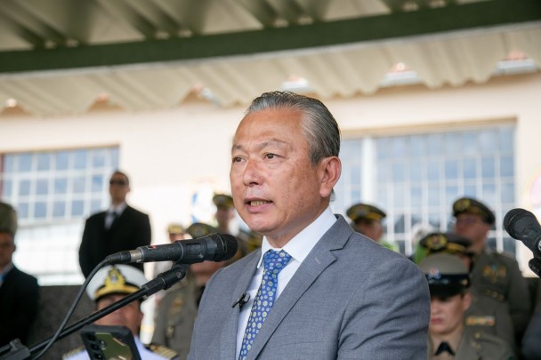 O secretário da Segurança Pública, Mário Ikeda, discursa durante a cerimônia de juramento. Ele usa terno cinza, camisa branca e gravata azul com detalhes em branco