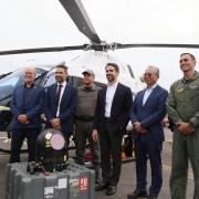 Foto mostra o governador Eduardo Leite em frente ao helic&oacute;ptero com outras autoridades e militares.